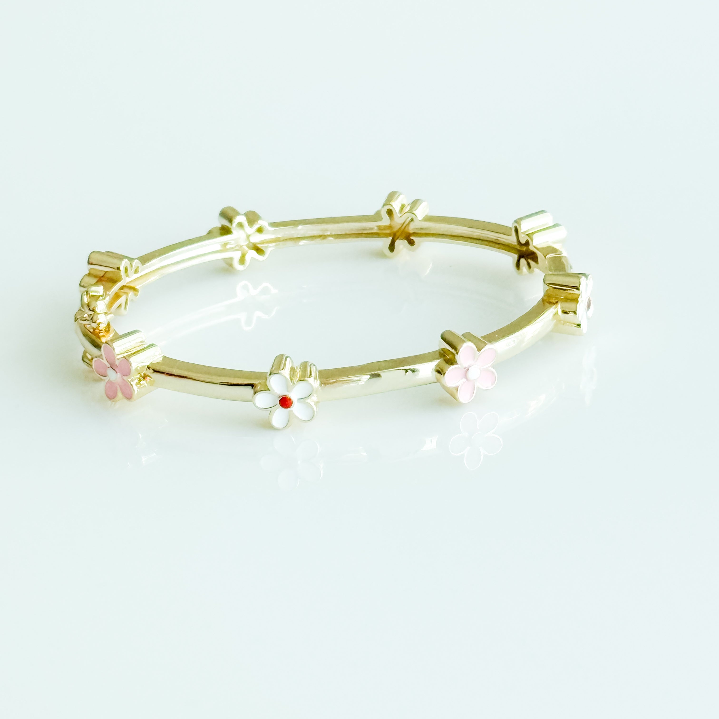 Gold bracelet with floral designs on a white background