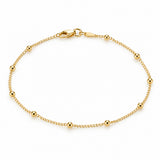 14K solid yellow gold beaded anklet with delicate chain, polished round beads, and lobster clasp on a white background