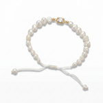 14K solid yellow gold adjustable bracelet with flat freshwater baroque pearls, white satin macramé cord, rectangular bezel cubic zirconia center, and gold end bead detail