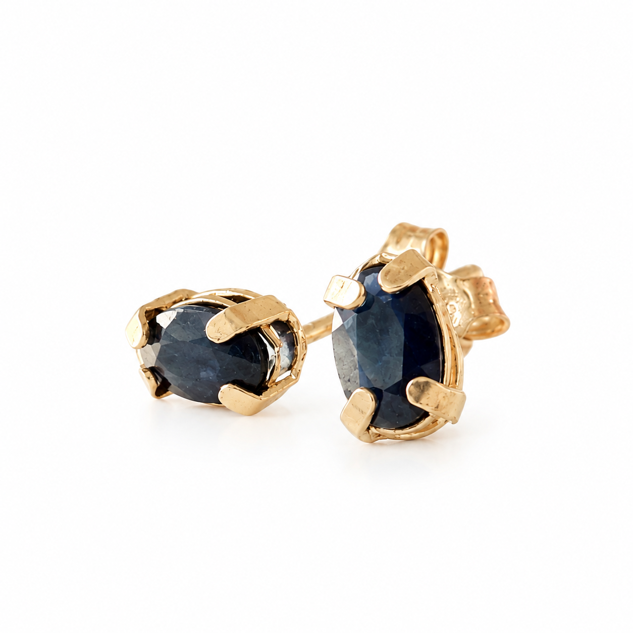 14K solid yellow gold stud earrings with oval dark blue sapphires in four-prong settings.