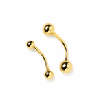A 14K solid yellow gold body piercing with two gold balls attached by a curved 14K solid yellow gold bar.