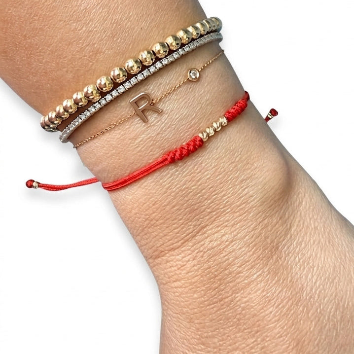 14K solid yellow gold adjustable red string bracelet with 3 D-cut gold balls styled in luxury bracelet stack on wrist